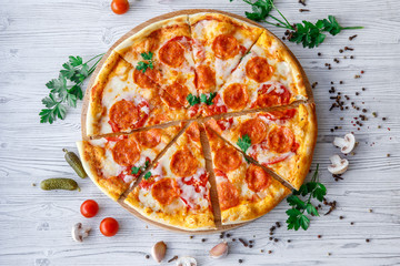 Italian pizza pepperoni on a light wooden background