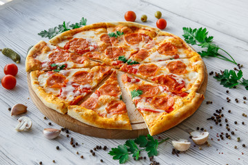 Italian pizza pepperoni on a light wooden background