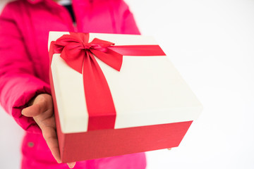 Woman hands holding Gift box with red bow on white background.Concept for delivery gift on holidays and winter time.