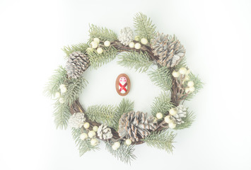 Nativity and Christmas season.Manger with wooden baby boy child Jesus Christ on Christmas round wreath on white background.Christmas religious nativity scene.