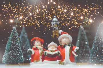Christmas caroling or Carolers singing outside with snows.Family group singing carol song on...