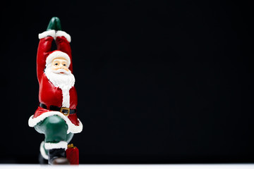 Santa Claus ready for give gift for Christmas eve and poses like a yoga practice be easily changed into overlay isolated on black background with copy space
