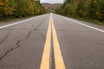 Pair of yellow lines on gray asphalt road. Canada
