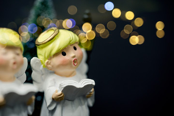 Christmas caroling or Carolers singing outside with snows.Angel group singing carol song on...