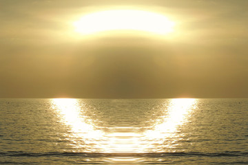 tramonto dorato con riflesso di luce a semicerchio sull'acqua del mare scintillante