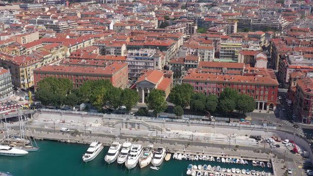 Aerial view of marine port and harbor with luxury yachts in Port de Nice in France in a summer sunny day. Action. Top view of white boats, city, and seafront.