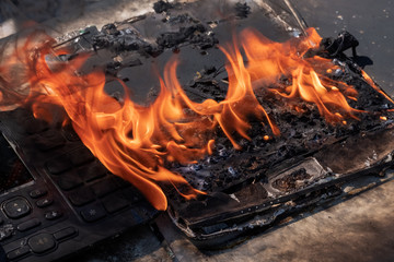 Fire in the office. Burnt laptop and phone. Loss of digital data. Military action, sabotage, or deliberate destruction. Safety during the operation of electrical appliances. Business insurance concept