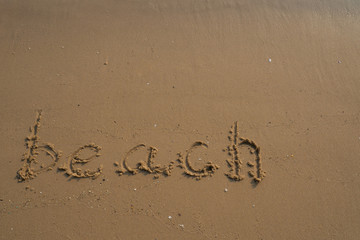 Vacation on the sand beach concept. Beach words written into the sand on the beach at Rayong, Thailand.