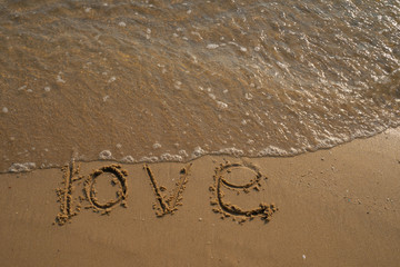 Love and Valentine concept. Love words written into the sand on the beach at Rayong, Thailand
