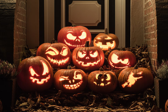 Night shot of illuminated pumpkins in front of a house