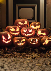 Fototapeta premium Night shot of illuminated pumpkins in front of a house