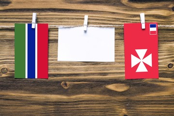 Hanging flags of Gambia and Wallis And Futuna attached to rope with clothes pins with copy space on...