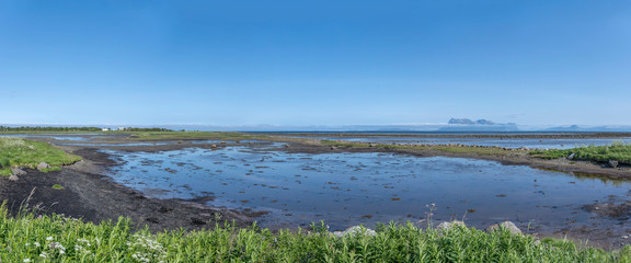 coastal landscape with steep islands in background,  near Dverberg, Norway