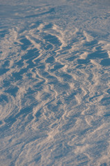 Wind patterns in snow on the surface of frozen lake in Finland in winter