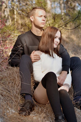 Beautiful young man hugs his girl in the woods