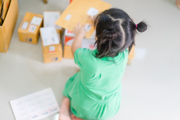 Startup Little girl packing parcels with sticky tape at warehouse.Concept for startup small business entrepreneur SME or freelance.