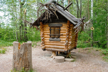 old hut from Russian fairy tales in the woods in the summer