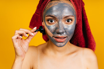 beautician client with black mask on her face