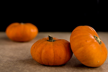 Small seasonal orange pumpkins with textured background