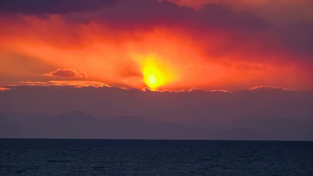 Timelapse of Sunset into Distant Mountain over Sea Channel in Japan 