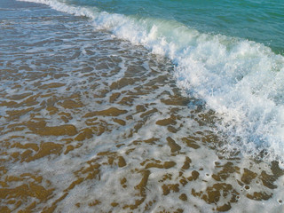 Closeup of the sea wave with surf and foam. High shutter speed fixation, diagonal view, low angle 