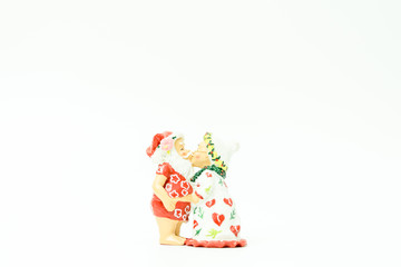 Miniature people : Santa Claus and mrs. Claus kissing and hugs in hawaii and ready for work in christmas season on white background.
