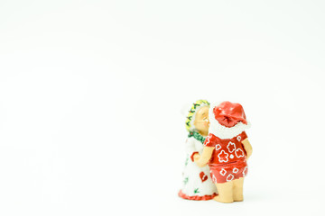 Fototapeta na wymiar Miniature people : Santa Claus and mrs. Claus kissing and hugs in hawaii and ready for work in christmas season on white background.