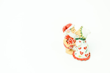 Miniature people : Santa Claus and mrs. Claus kissing and hugs in hawaii and ready for work in christmas season on white background.