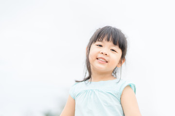 Little girl child showing front teeth with big smile: Healthy happy funny smiling face young adorable lovely female kid with new tooth dental loss: Joyful portrait of asian elementary school student