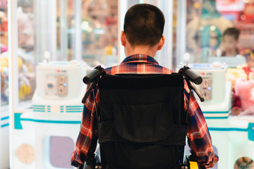 Disabled child on wheelchair having fun have fun playing the dollhouse game cabinet, Special children's lifestyle, Life in the education age of special need kids, Happy disability kid concept.