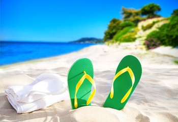 Colored slippers and towel at beach sea ocean