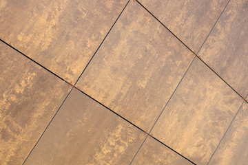 Diagonal view at beige-brown uneven coloured tile on wall, for architecture design