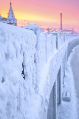 Winter beautiful sunset and mist above the water of river. Frosty weather, trees are covered with fluffy hoarfrost - urban winter landscape in Siberia, Russia