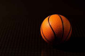 orange basket ball on a checkered dark background