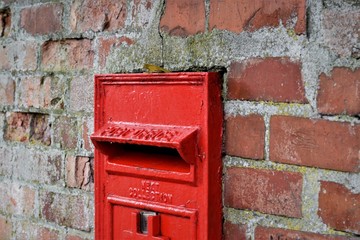red mailbox on brick wall