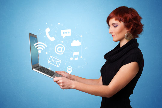 Woman holding laptop with online services symbols