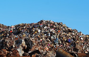 Big pile of cans, aluminum and scrap ferrous material under the sun, waiting to be recycled.