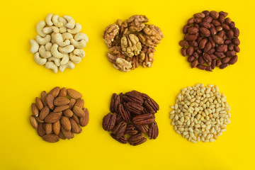 Set of different nuts  on the yellow  background. Top view. Closeup.