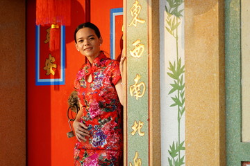 A beautiful Chinese woman, a red cheongsam, is watching the local culture of Chinese temples.