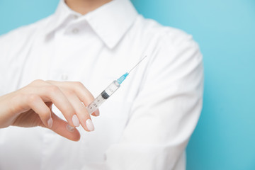 Beauty spa doctor holding syringe on blue background. Concept lip enlargement injection, anti-aging...