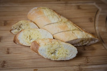Tasty garlic bread, baguette on kitchen board