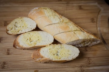 Tasty garlic bread, baguette on kitchen board