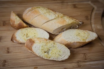 Tasty garlic bread, baguette on kitchen board