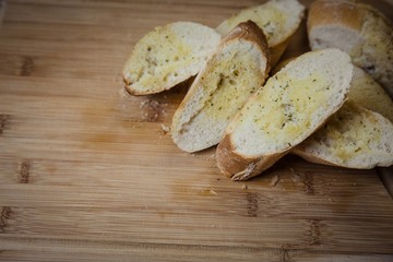 Tasty garlic bread, baguette on kitchen board