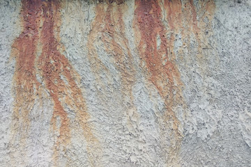 Drips of rust on a gray textured wall