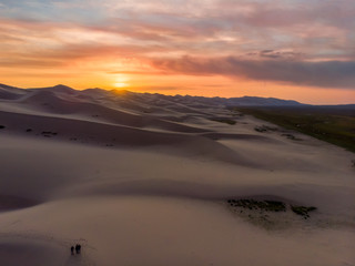 Fototapeta na wymiar Three people at Singing Sand Dunes at Khongoryn Els, Gobi Gurvasaikhan National Park, Gobi Desert, Mongolia, Mongolian, Asia, Asian.