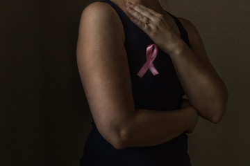 October is breast cancer awareness month,a woman holds a pink ribbon to support people living and...