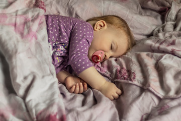 The little sleeping girl in the bed. Lifestyle