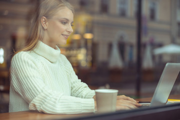Female freelancer writing an article in a cafe