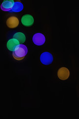 The blurred background of a Christmas garland on a black background is out of focus. Abstract Christmas background.